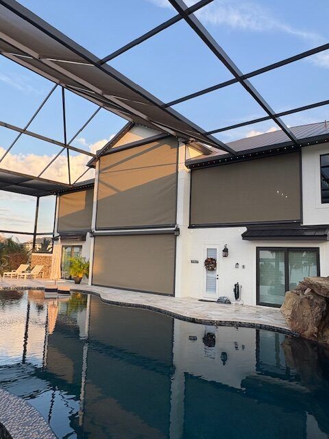 A motorized screen lowered across a two-storey pool lanai