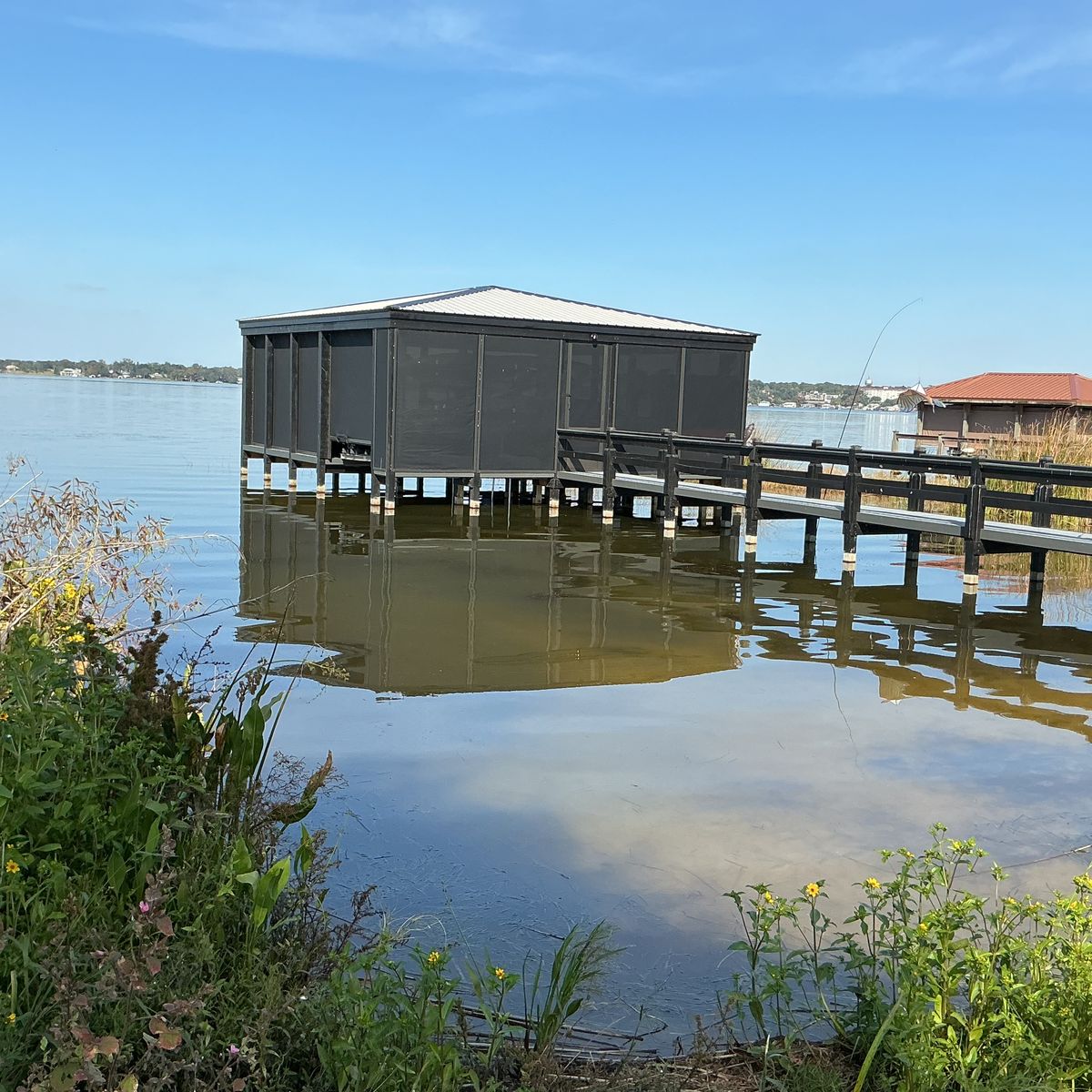 A screened dock house seen from the lakeshore